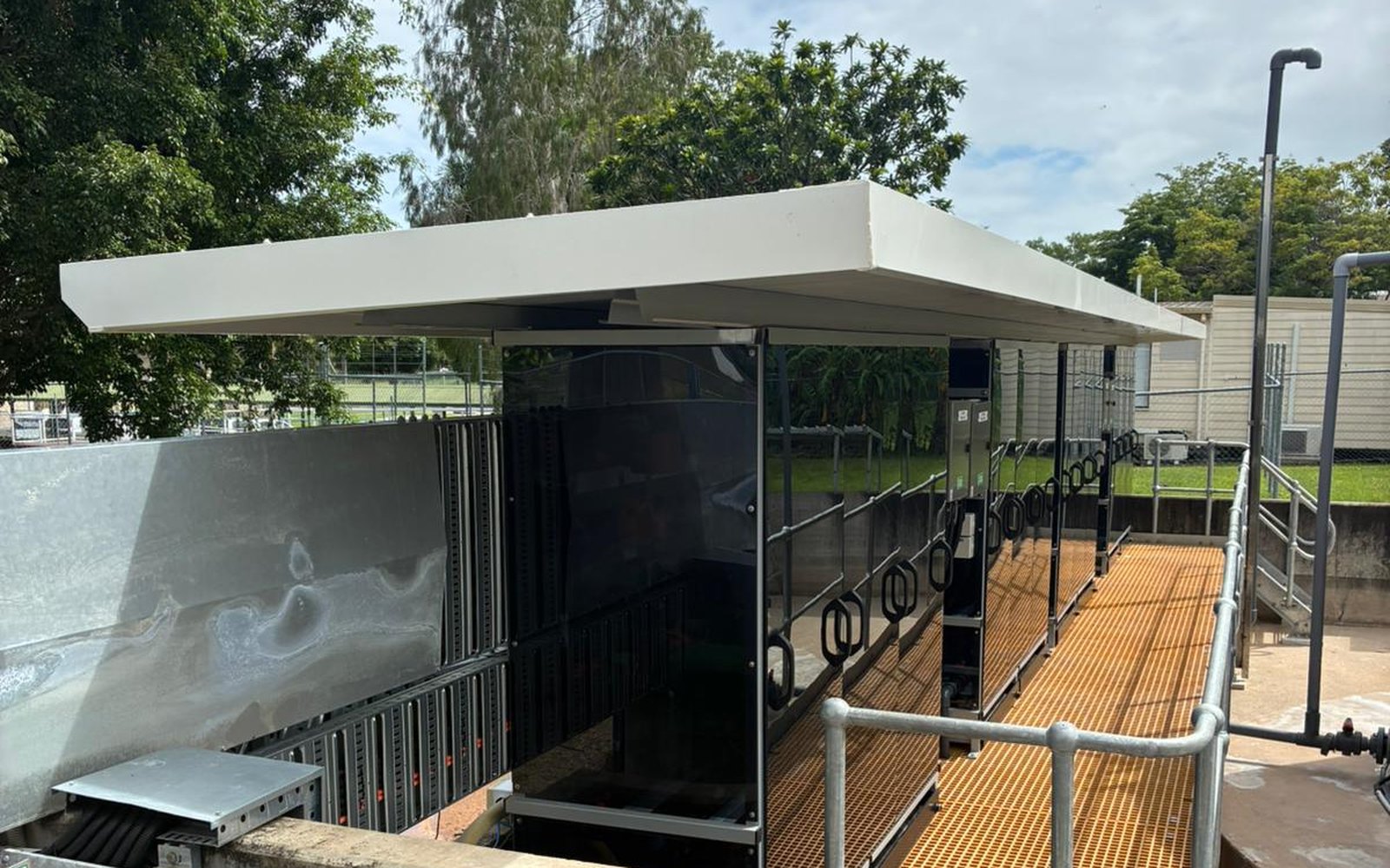 Chemical Dosing Skids — dosing equipment on FRP grating platform with new canopy and safety handrails