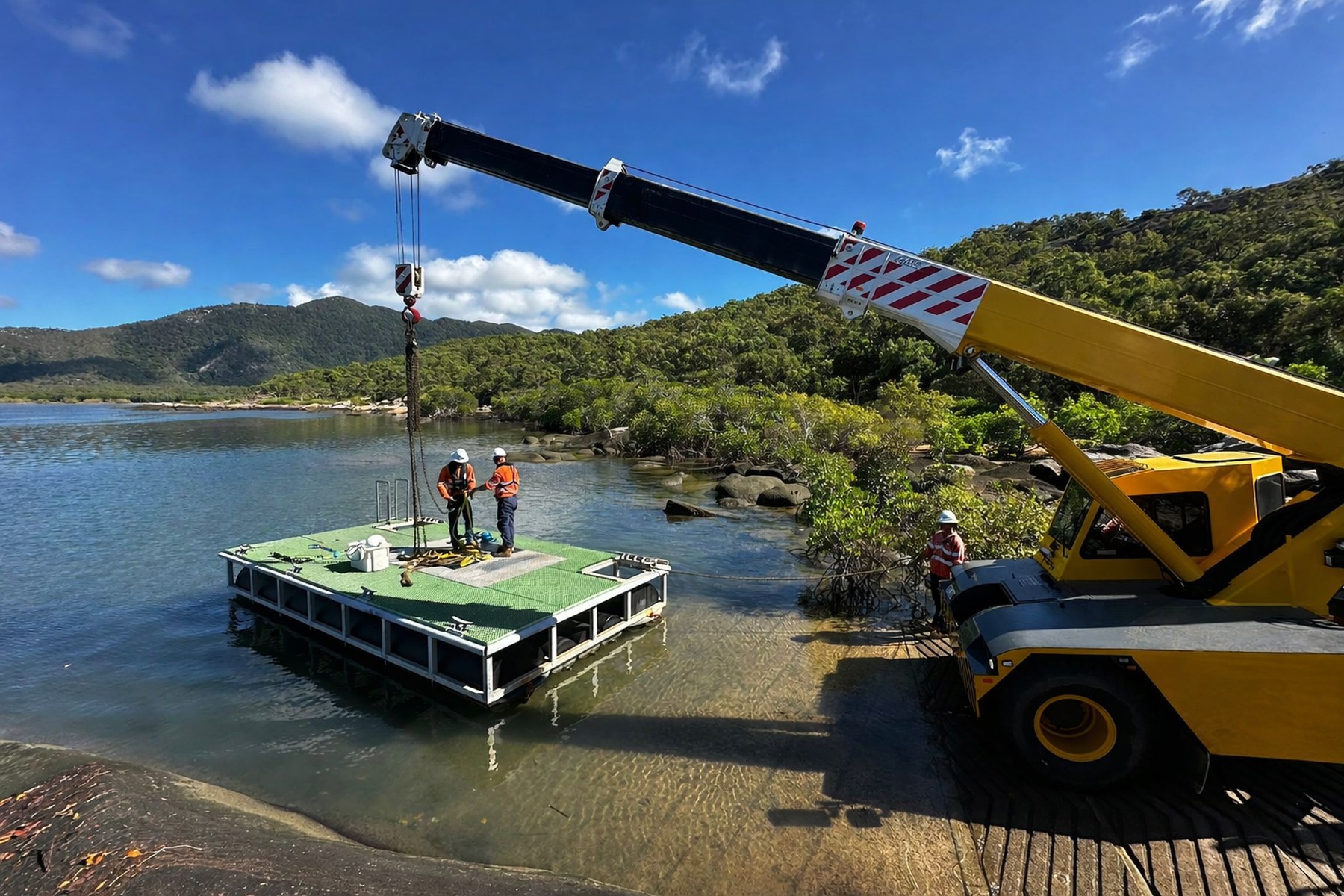 Vision Constructions crane lifting a service pontoon into water at a remote North Queensland coastal site